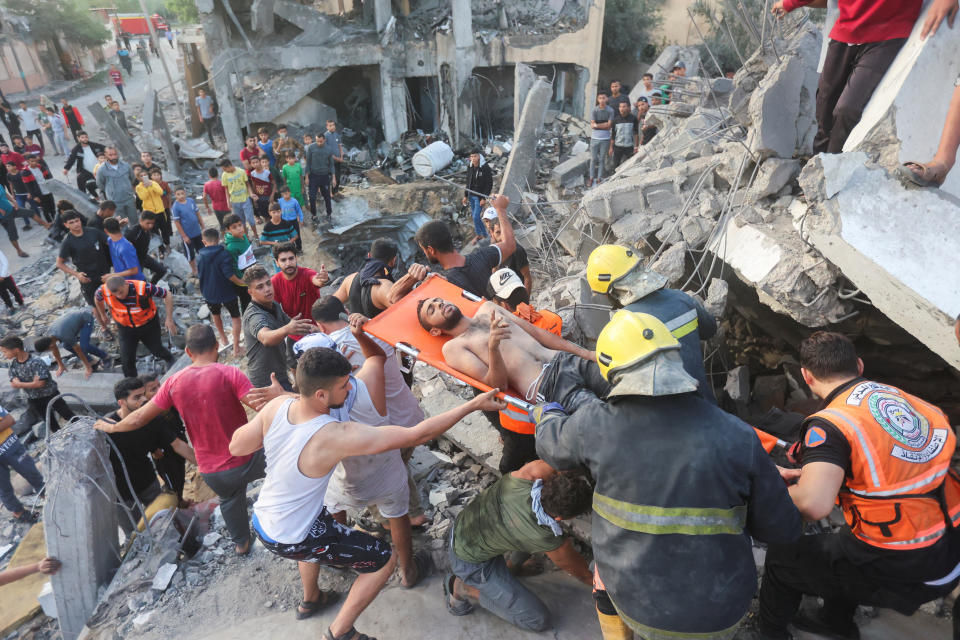 Palestinians remove a man from under the rubble of a house destroyed by Israeli strikes in Khan Younis.