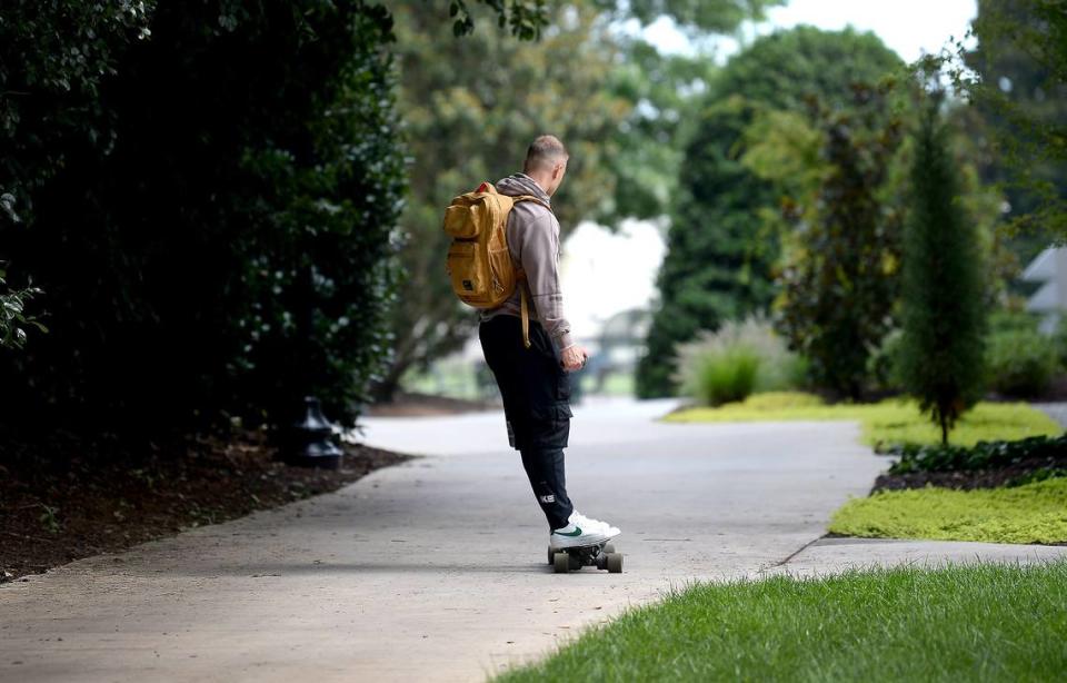 Carolina Panthers running back Christian McCaffrey rides a skateboard down a path at Wofford College in Spartanburg on Tuesday. McCaffrey missed 13 of 16 games in 2020 due to injury.