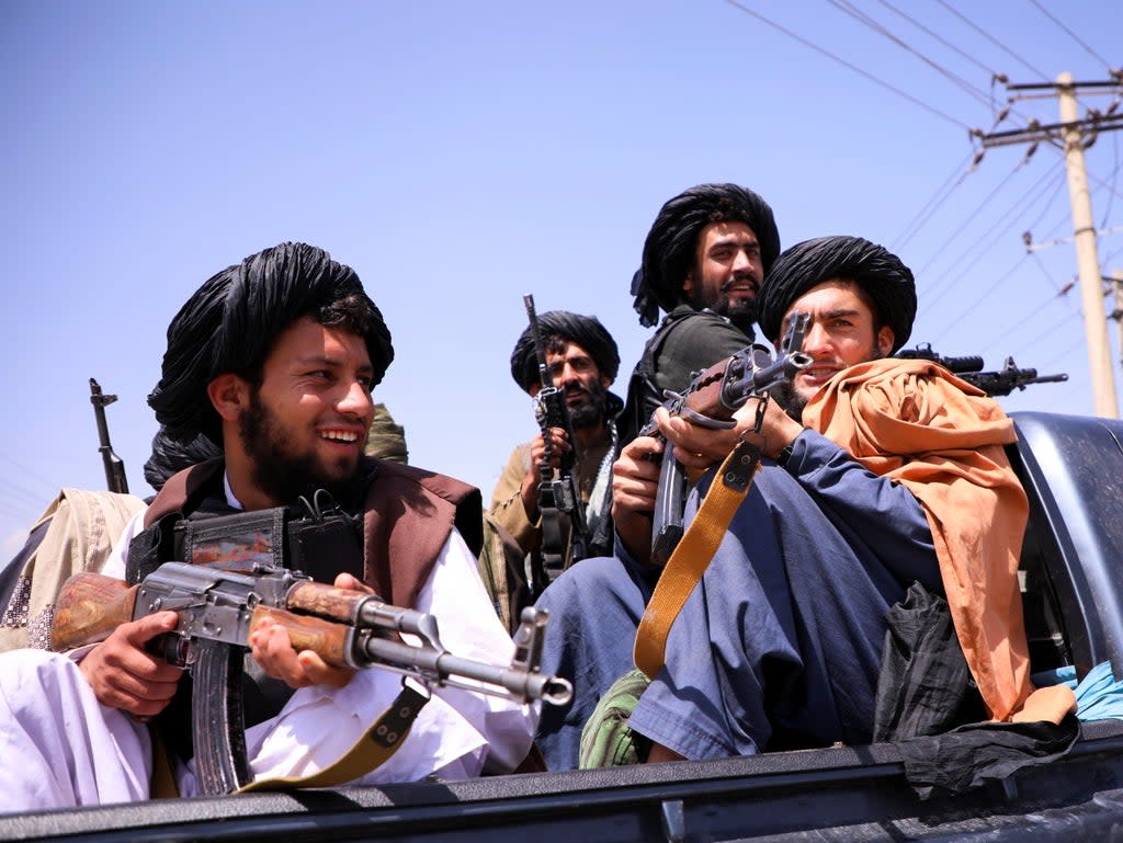 Taliban fighters outside the Hamid Karzai airport in Kabul as they celebrate victory.  (REUTERS)