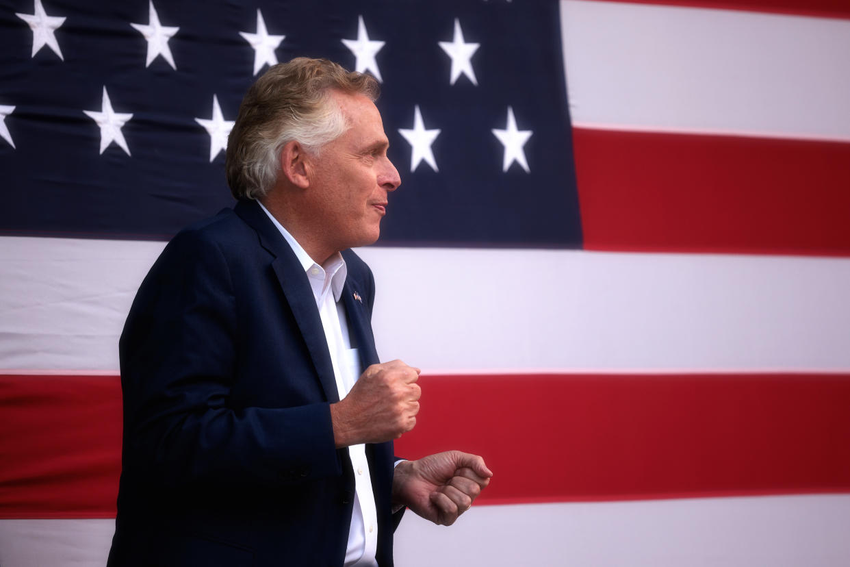 Terry McAuliffe in profile in front of an American flag.