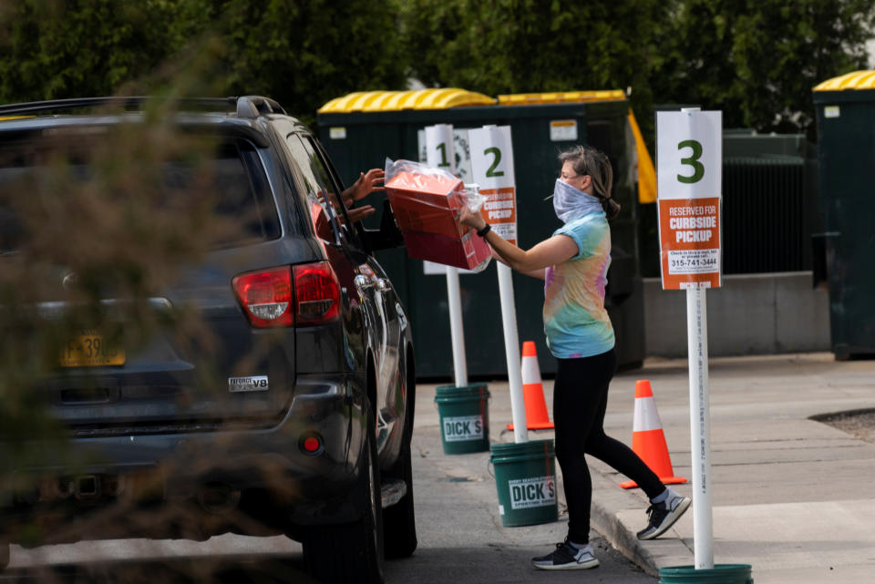 An employee of Dick's Sporting Goods in Destiny USA mall delivers products to a shopper, as customers pick up goods from retailers offering curbside pick up as the coronavirus disease (COVID-19) restrictions ease in Syracuse, New York, U.S., May 15, 2020. REUTERS/Zachary Krahmer