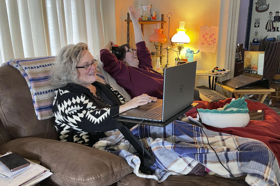 Angelina Mistretta, a 16-year-old junior at City Honors High School shares the couch with her mother Wendy Mistretta, in Buffalo, NY., Feb. 17, 2021. These days, her mother, Wendy, works beside Angelina on the living room couch. (AP Photo/Carolyn Thompson)