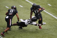 Cincinnati running back Gerrid Doaks, right, tries to escape the grasp of Army's Marquel Broughton during the first half of an NCAA college football game Saturday, Sept. 26, 2020, in Cincinnati, Ohio. (AP Photo/Jay LaPrete)