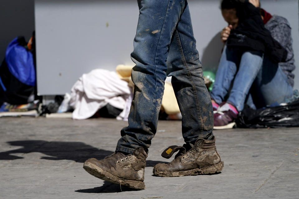 A migrant's muddy shoes are seen without laces as he walks off the customs checkpoint in Reynosa, Mexico, after being deported by U.S. Customs and Border Protection agents, Thursday, March 18, 2021. Migrants are forced to give up their shoelaces as a security measure after being taken into custody. (AP Photo/Julio Cortez)