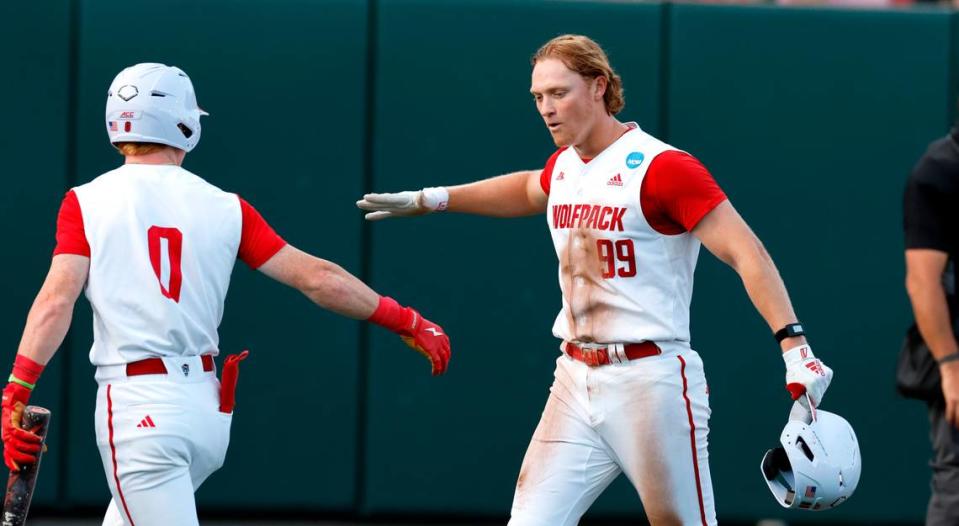 N.C. State’s Alec Makarewicz (99) celebrates with Luke Nixon (0) after scoring on a hit by Brandon Butterworth in the third inning during N.C. State’s game against Bryant in the NCAA Raleigh Regional at Doak Field Friday, May 31, 2024.