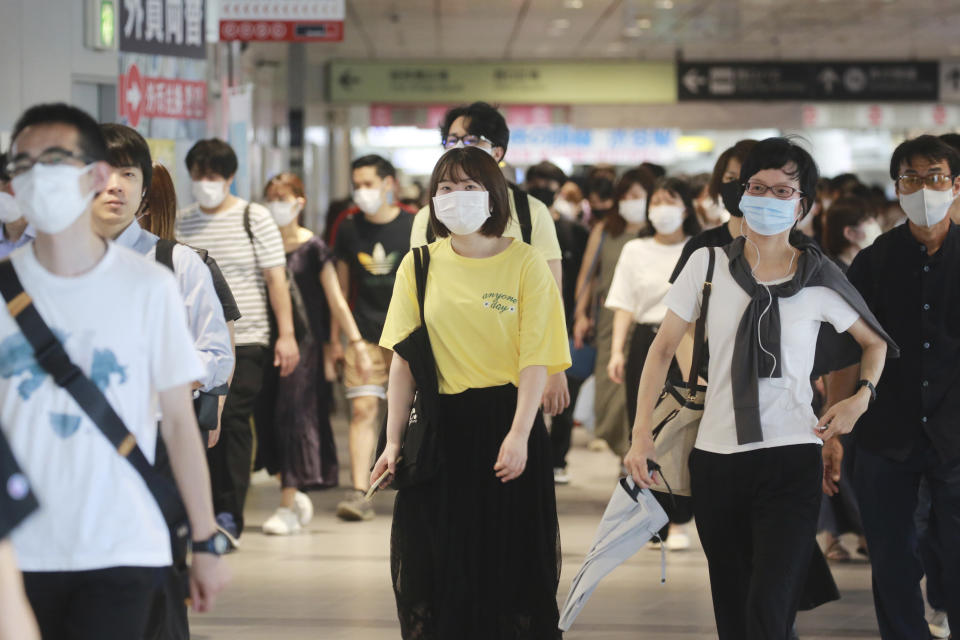 People wearing face masks to protect against the spread of the coronavirus walk at a train station in Tokyo, Wednesday, July 28, 2021. Tokyo Gov. Yuriko Koike on Wednesday urged younger people to cooperate with measures to bring down the high number of infections and get vaccinated, saying their activities are key to slowing the surge during the Olympics. On Tuesday, the Japanese capital reported 2,848 new cases, exceeding its previous record in January. (AP Photo/Koji Sasahara)