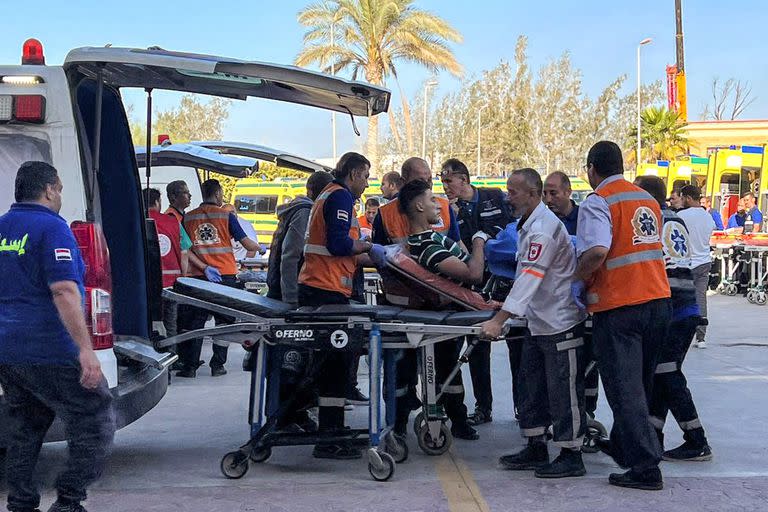 Paramédicos egipcios trasladan en una camilla a un palestino herido en el lado egipcio del paso fronterizo de Rafah con la Franja de Gaza, en la provincia nororiental del norte del Sinaí, el 6 de noviembre de 2023, en medio de los continuos combates entre Israel y el movimiento palestino Hamas.