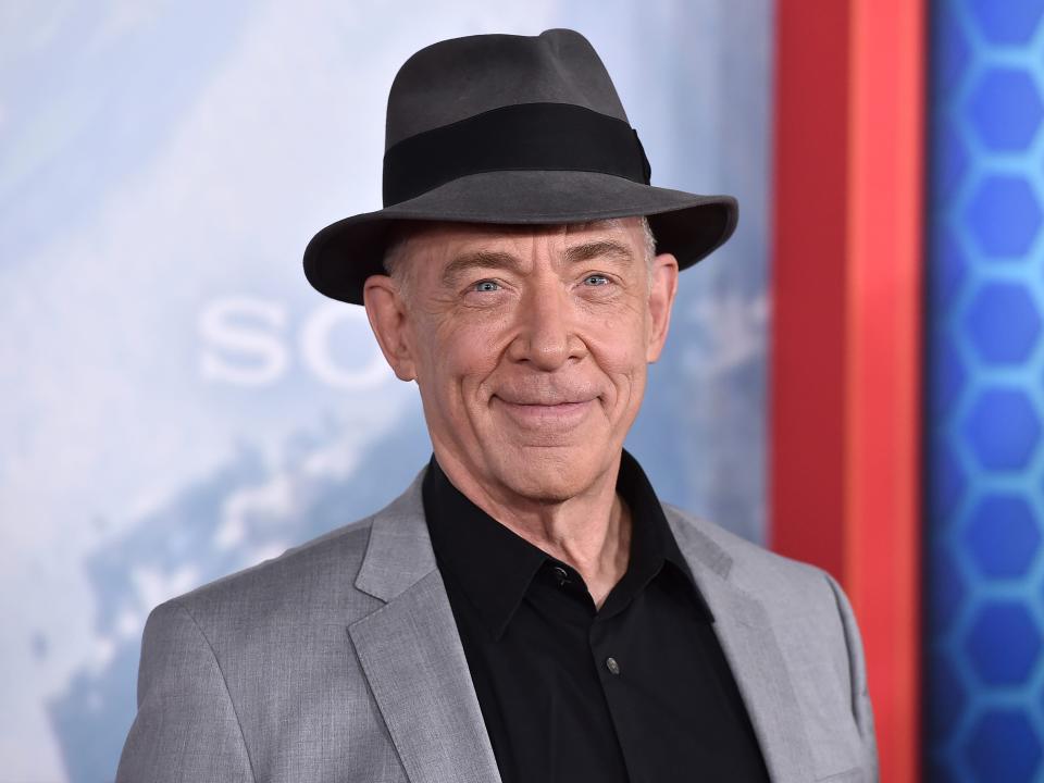 J.K. Simmons wears a black shirt, gray blazer, and dark gray hat at the LA premiere of "Spider-Man: No Way Home."