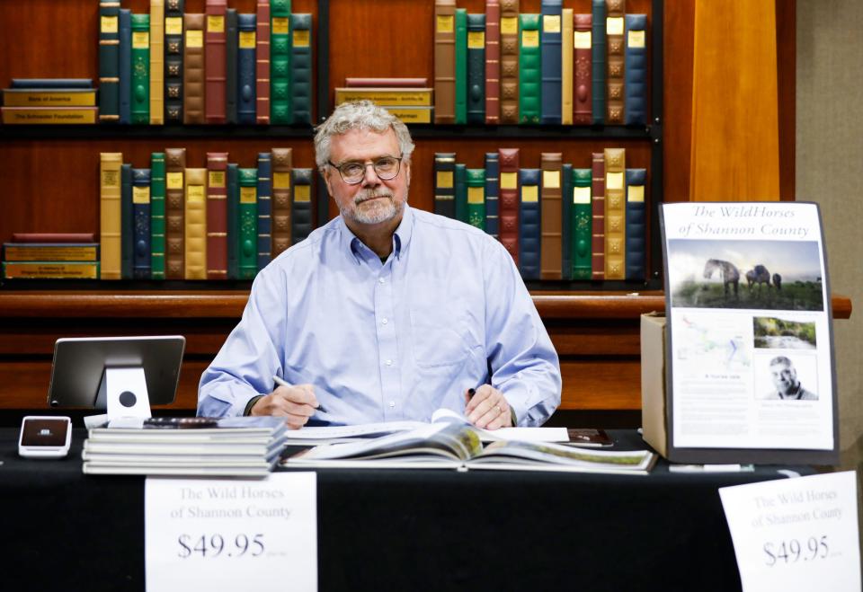 Former News-Leader photo editor Dean Curtis at a book signing of his book "The Wild Horses of Shannon County, Missouri", on Saturday, Nov. 19, 2022 at the Library Center. Curtis has been photographing the wild horses of Shannon County for over a decade and turned his photos into a 128-page coffee table book.