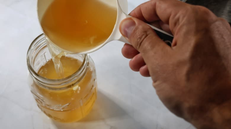 pouring shrub syrup into jar