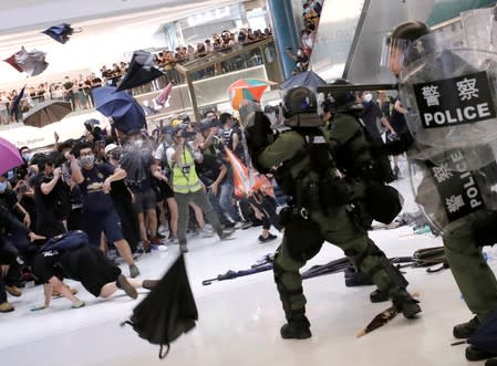 FILE PHOTO: Riot police use pepper spray to disperse pro-democracy activists inside a mall after a march at Sha Tin District of East New Territories, Hong Kong