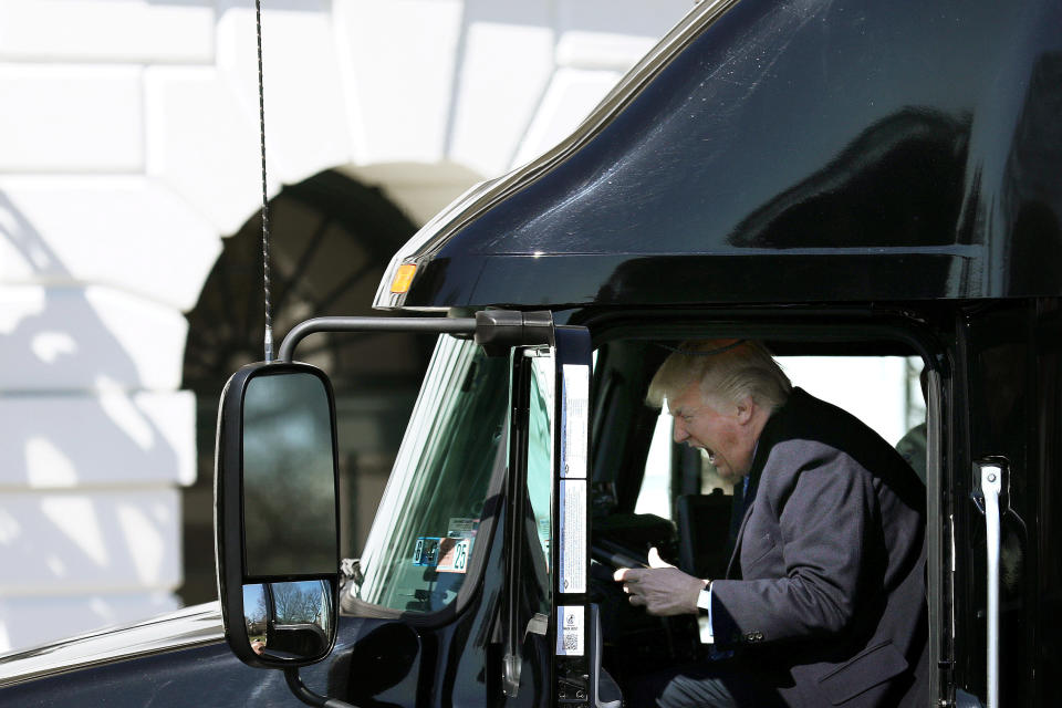 Trump reacts as he sits on a truck while he welcomes truckers and CEOs to attend a meeting regarding health care at the White House on March 23, 2017.