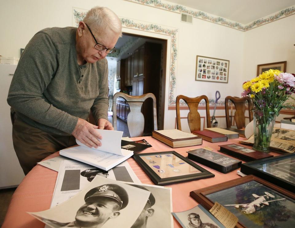 Dave Baker looks through the book Army officials gave the family explaining how they identified his uncle Lt. Col. Addison Baker.