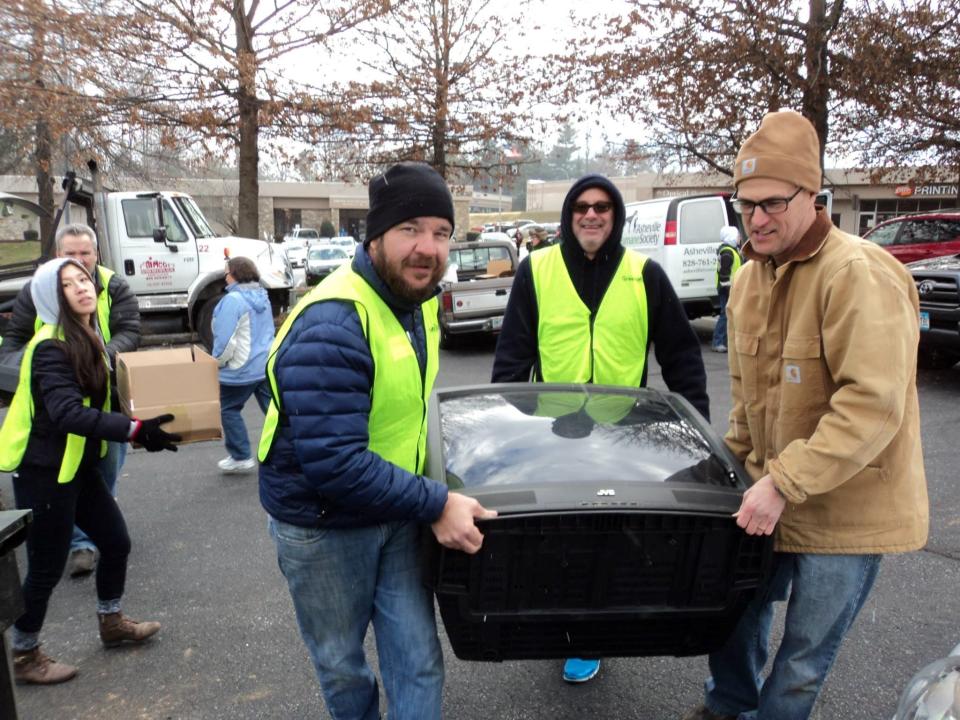 Eric Bradford, left, helps carry a TV to be recycled at a past Asheville GreenWorks Hard 2 Recycle event.