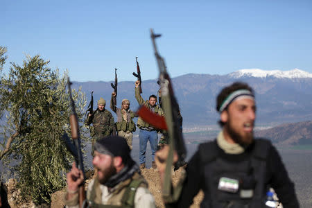 Turkish-backed Free Syrian Army fighters react as they hold their weapons near the city of Afrin, Syria February 19, 2018. REUTERS/Khalil Ashawi