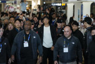 CORRECTS DATE - Los Angeles Dodgers' Shohei Ohtani, center, and his wife, Mamiko Tanaka, walk with security during the baseball team's arrival at Incheon International Airport, Friday, March 15, 2024, in Incheon, South Korea, ahead of the team's baseball series against the San Diego Padres. (AP Photo/Lee Jin-man)