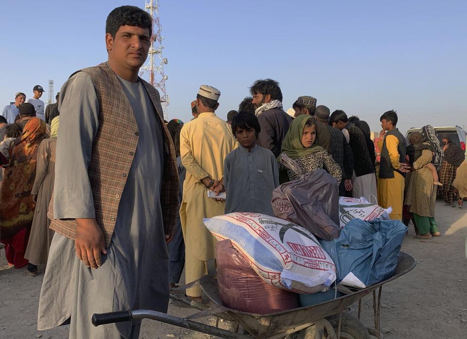 An Afghan man prepares to push a wheelbarrow with items of food distributing by an Islamabad-based Christian organization on the outskirts of Chaman, a border town in the Pakistan's southwestern Baluchistan province, Tuesday, August 31, 2021. Dozens of Afghan families have crossed into Pakistan through the southwestern Chaman border a day after the U.S. wrapped up its 20-year military presence in the Taliban-controlled country. (AP Photo)