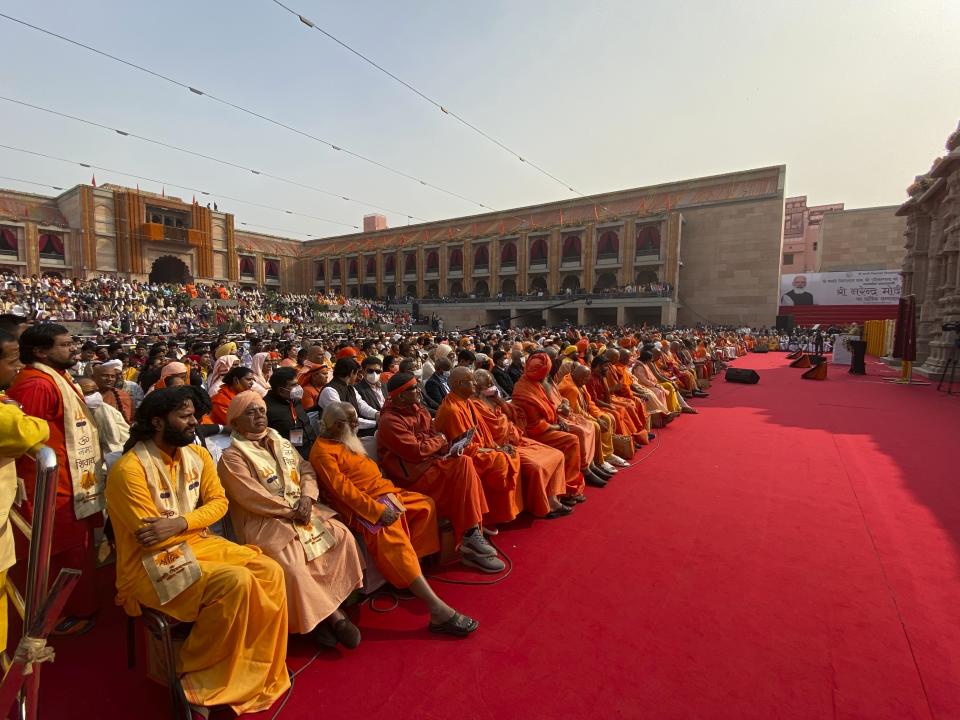 Hindu holy men and others listen as Indian Prime Minister Narendra Modi, right, speaks during the inauguration of Kashi Vishwanath Dham Corridor, a promenade that connects the sacred Ganges River with the centuries-old temple dedicated to Lord Shiva in Varanasi, India, Monday, Dec. 13, 2021. (AP Photo/Rajesh Kumar Singh)