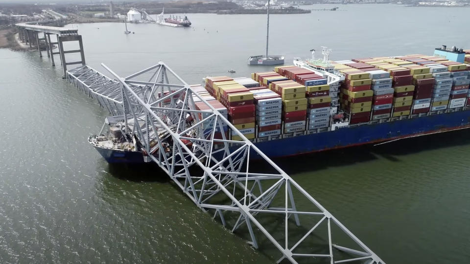 In this image taken from video released by the National Transportation and Safety Board, the cargo ship Dali is stuck under part of the structure of the Francis Scott Key Bridge after the ship hit the bridge, Tuesday, March 26, 2024, in Baltimore. (NTSB via AP)