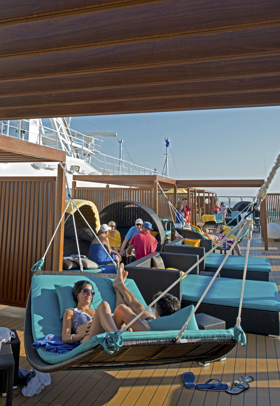 In this June 17, 2012 photo provided by Carnival Cruise Lines, vacationers aboard the Carnival Breeze relax at Serenity, an adults-only area offering plush chaise lounges and chairs, whirlpools, and a dining area with salads, wraps and other light fare. Multi-generational groups are a growing segment of cruise passengers. To accommodate the diverse needs of old and young passengers, ships are expanding areas for youth activities while at the same time creating more adult-only pools and quiet areas where adult passengers can nap, sun, or read a book. Carnival ships call these areas “Serenity Spaces.” (AP Photo/Carnival Cruise Lines, Andy Newman)