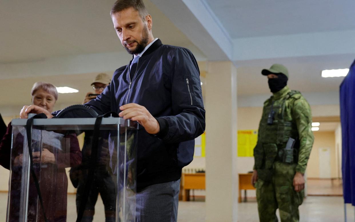 See-through ballot boxes and masked soldiers at a polling station in Donetsk - ALEXANDER ERMOCHENKO /REUTERS