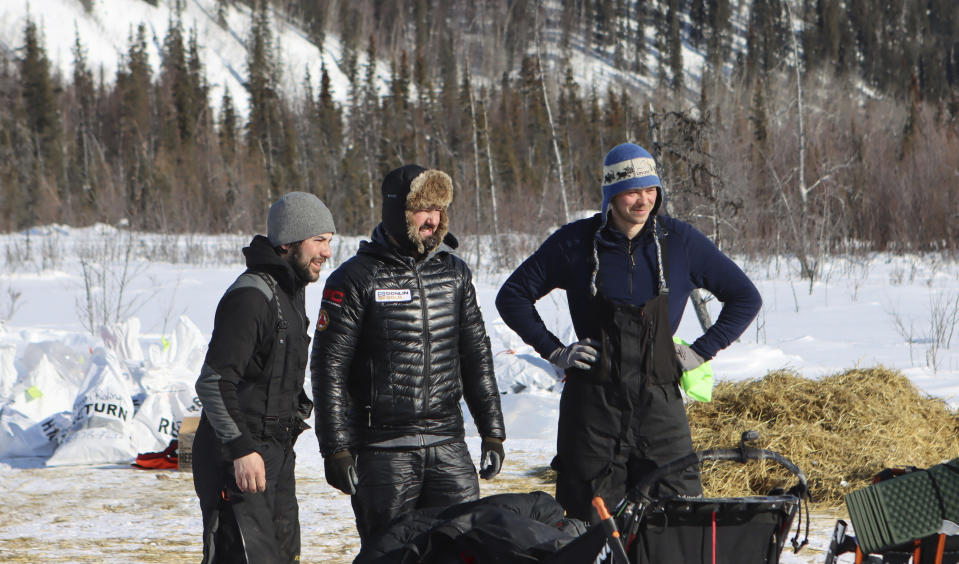 Past Iditarod champions Joar Ulsom, right, and Pete Kaiser pose for a photo with Richie Diehl, left, in the Ophir, Alaska, during the Iditarod Trail Sled Dog Race on Friday, March 12, 2021. The three are close friends and have been traveling close together for sections of the race. (Zachariah Hughes/Anchorage Daily News via AP, Pool)