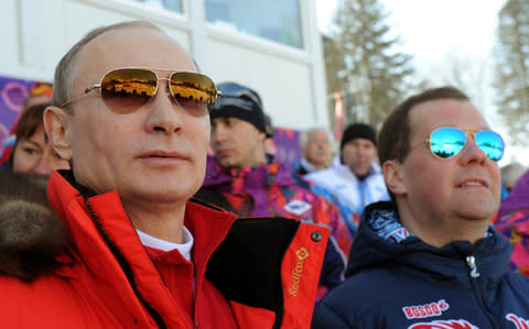 Vladimir Putin and Russian Premier Dmitry Medvedev watch the men's 4x10 km cross-country relay at the 2014 Winter Olympics in Krasnaya Polyana, Russia - Credit: AP