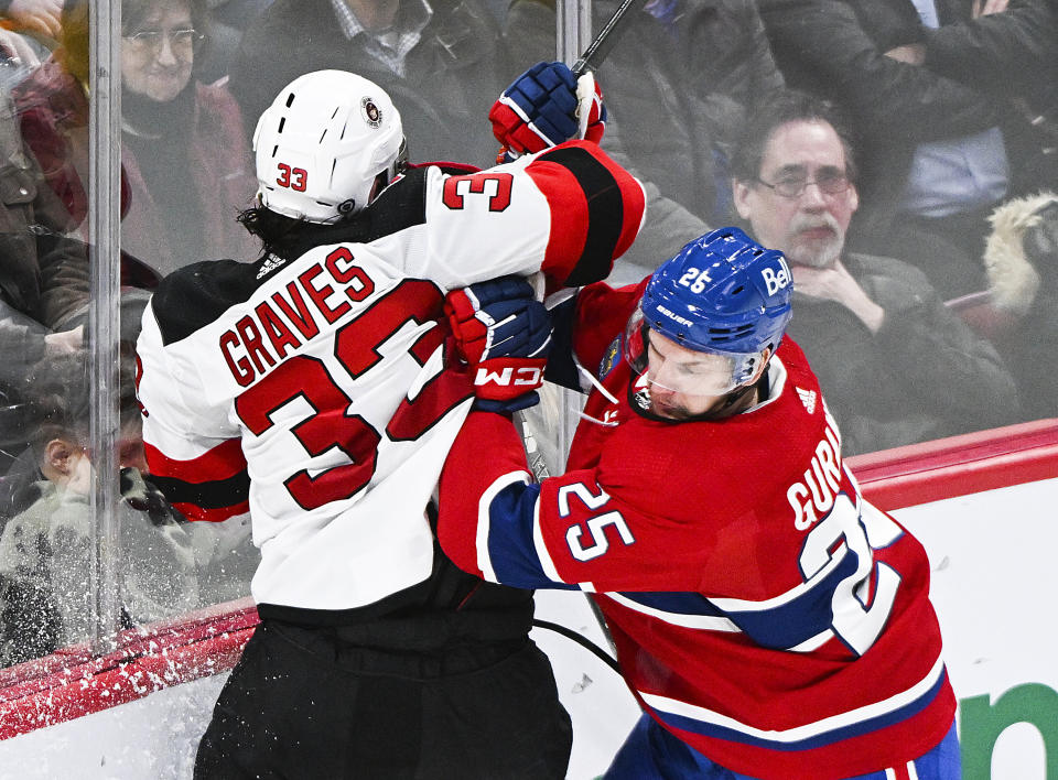 Montreal Canadiens' Denis Gurianov (25) checks New Jersey Devils' Ryan Graves during the third period of an NHL hockey game Saturday, March 11, 2023, in Montreal. (Graham Hughes/The Canadian Press via AP)