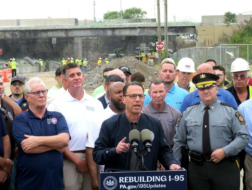 Pennsylvania Governor Josh Shapiro (center) takes questions from the media along Cottman Avenue with the closed section of Route 95 behind him in Northeast Philadelphia, PA, Wednesday, June 14, 2023.  He announced the plan to reconstruction the bridge after a temporary structure to carry traffic in built.  