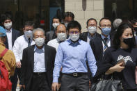 People wearing face masks to protect against the spread of the coronavirus walk on a street in Tokyo, Tuesday, April 20, 2021. (AP Photo/Koji Sasahara)