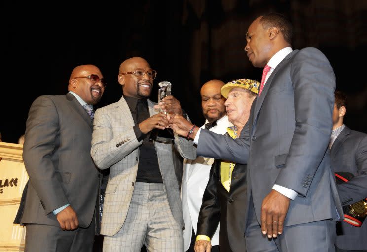 Hall of Fame boxer Sugar Ray Leonard (R) presents an award to Floyd Mayweather (second from left) at the Nevada Boxing Hall of Fame ceremony in 2015. (Getty Images)