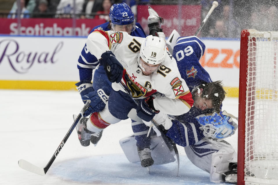 Florida Panthers left wing Matthew Tkachuk (19) crashes into Toronto Maple Leafs goaltender Joseph Woll (60) as Leafs' Matthew Knies defends during the third period of an NHL hockey game in Toronto on Tuesday, Nov. 28, 2023. (Frank Gunn/The Canadian Press via AP)