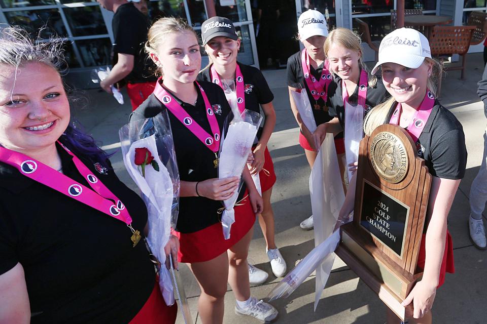 Los miembros del equipo de golf femenino de Gilbert celebran con su trofeo del campeonato estatal Clase 3A 2024 después de repetir como campeones estatales con una puntuación récord 3A de 608 en 36 hoyos durante el torneo estatal de golf femenino 3A el viernes en el campo de golf Pheasant Ridge en Cedar Falls. Iowa.