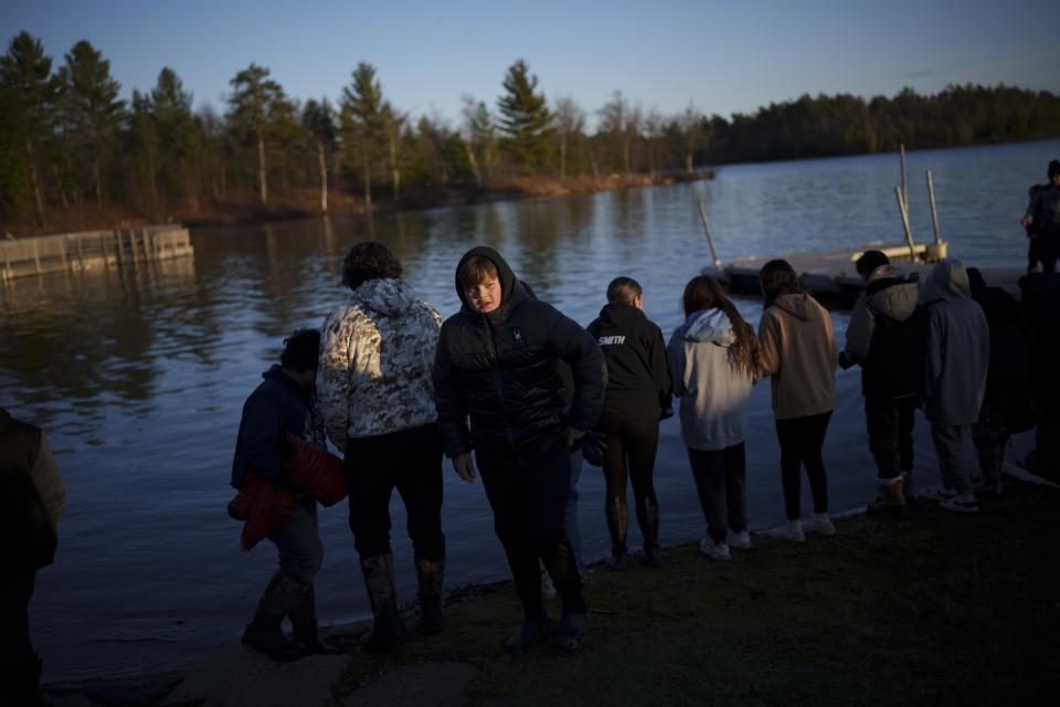 Young members of the Lac du Flambeau Band of Lake Superior Chippewa Indians line up to put tobacco in the lake as an offering during a youth spearfishing event on the Lac du Flambeau Reservation, Saturday, April 20, 2024, in Lac Du Flambeau, Wis. (AP Photo/John Locher)