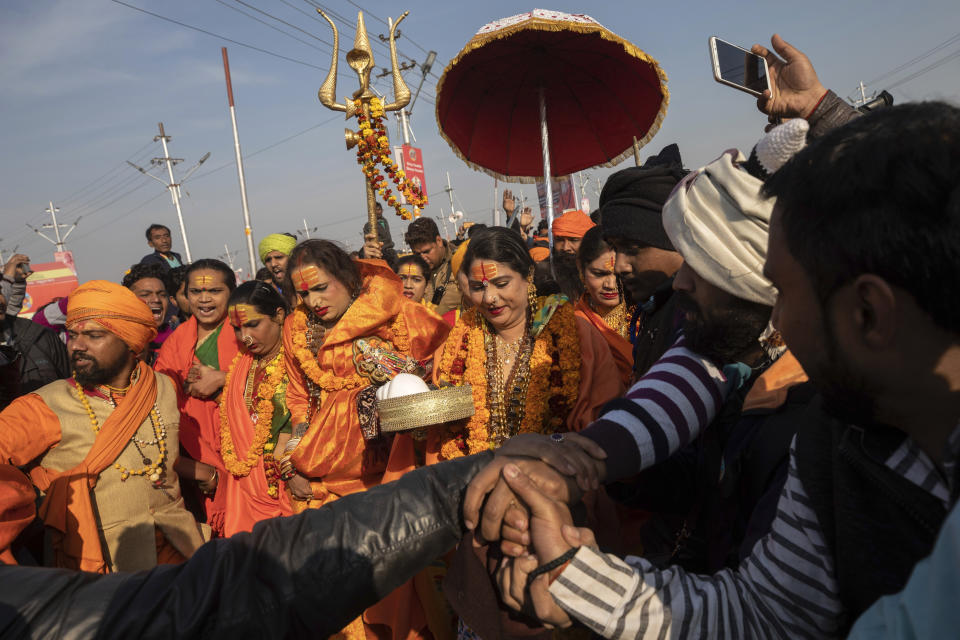 In this Jan. 15, 2019, photo, Laxmi Narayan Tripathi, center left, a transgender activist and founder of the "Kinnar Akhara" monastic order arrive with other members of the order for a spiritual-cleansing dip on the auspicious Makar Sankranti day during the Kumbh Mela festival in Prayagraj, Uttar Pradesh state, India. Kinnars celebrated their inclusion at Kumbh as a victory, but their greater acceptance by Hinduism’s most powerful leaders, in the religious and political spheres, remains to be seen. Unlike other akharas, which are only open to Hindu men, Kinnar, founded in 2015, is open to all genders and religions. (AP Photo/Bernat Armangue)