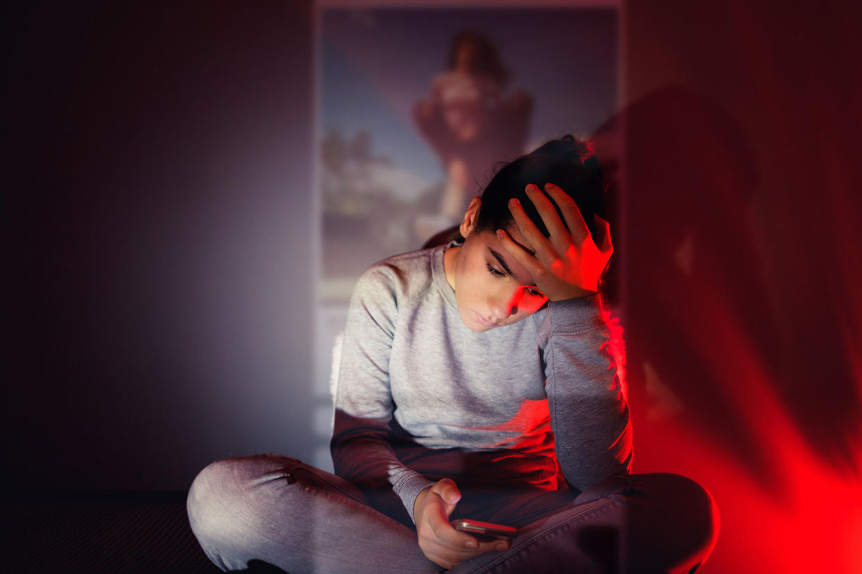 A 13-year-old girl is using her smartphone in the dark roomGetty Images