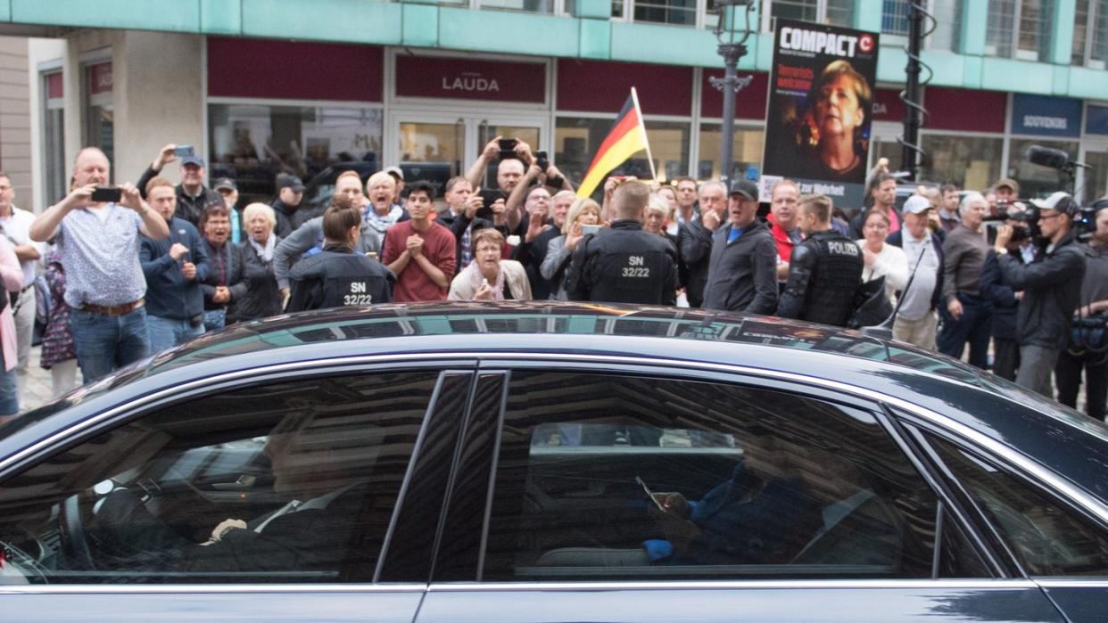 Der Dienstwagen der Bundeskanzlerin fährt an Demonstranten vor dem Albertinum vorbei. Foto: Sebastian Kahnert