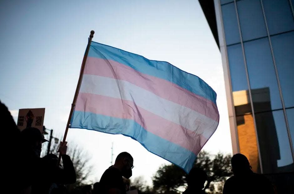 A protester waves a transgender pride flag during a protest at the University of North Texas in Denton on March 23, 2022.