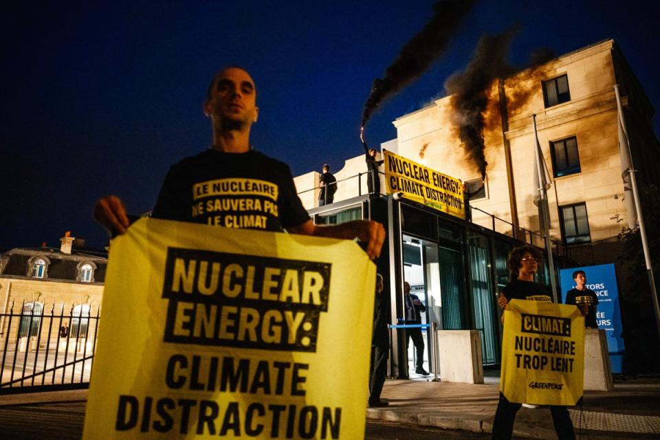Greenpeace activists light torches and hold anti-nuclear banners prior to the opening of a nuclear energy conference in Germany in September (AFP via Getty Images)