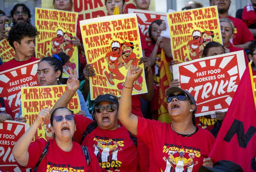 LOS ANGELES, CA-JULY 13, 2023: Angelica Hernandez, left, an employee for the past 20 years at a McDonald's restaurant in Monterey Park, and Anneisha Williams, right, an employee for the past 10 years at a Jack in the Box restaurant in Los Angeles, rally with other fast food workers from across Los Angeles during a rally outside of the Los Angeles Chamber of Commerce in Los Angeles. The rally was held to raise awareness of their push for better working conditions. (Mel Melcon / Los Angeles Times)