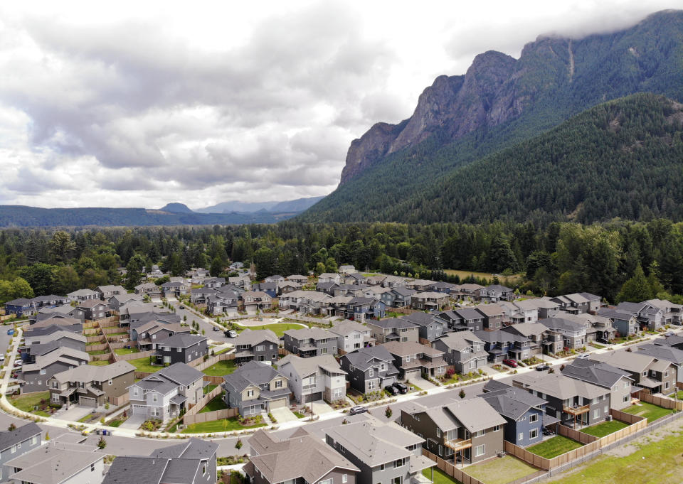 In this photo taken July 24, 2019, a development of houses stand next to a forest and in view of Mt. Si in the Cascade foothills of North Bend, Wash. The region, famous for its rainfall, has long escaped major burns even as global warming has driven an increase in both the size and number of wildfires elsewhere in the American West. But according to experts, previously too-wet-to-burn parts of the Pacific Northwest now face an increasing risk of significant wildfires because of climate change. (AP Photo/Elaine Thompson)