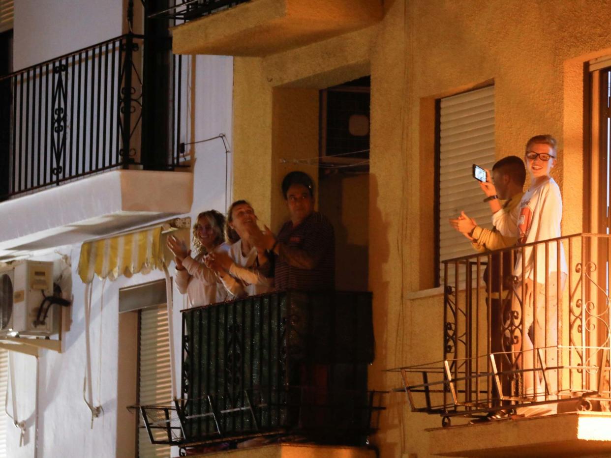 Family members applaud from their balconies during a call on social media to thank Spanish medical staff: REUTERS/Jon Nazca