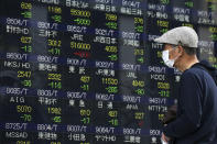 A man looks at an electronic stock board of a securities firm in Tokyo, Wednesday, April 9, 2014. Asian stocks were mostly higher Wednesday, except for Japan where the main index tumbled on a rise in the yen. (AP Photo/Eugene Hoshiko)