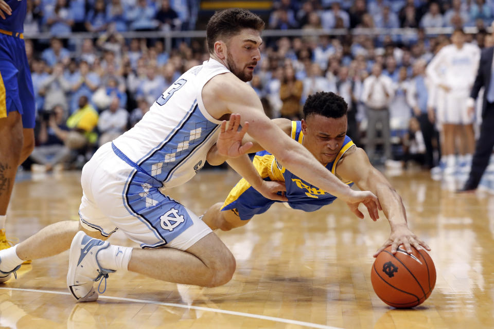 North Carolina guard Andrew Platek (3) and Pittsburgh guard Trey McGowens (2) dive for a loose ball during the second half of an NCAA college basketball game in Chapel Hill, N.C., Wednesday, Jan. 8, 2020. (AP Photo/Gerry Broome)