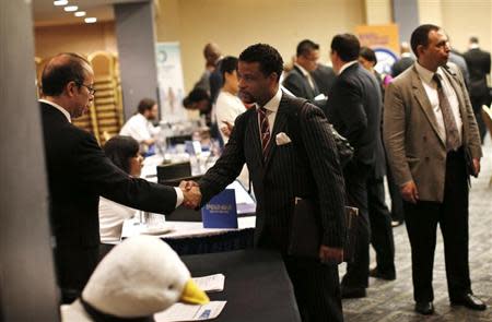 A job seeker (R) meets with a prospective employer at a career fair in New York City, October 24, 2012. REUTERS/Mike Segar