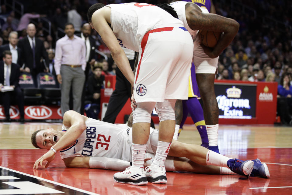 Blake Griffin grimaces in pain after the collision with Austin Rivers that injured his knee. (AP)