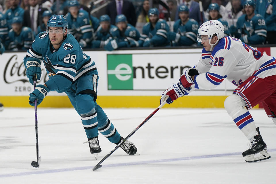 San Jose Sharks right wing Timo Meier (28) skates with the puck next to New York Rangers left wing Jimmy Vesey (26) during the first period of an NHL hockey game in San Jose, Calif., Saturday, Nov. 19, 2022. (AP Photo/Jeff Chiu)