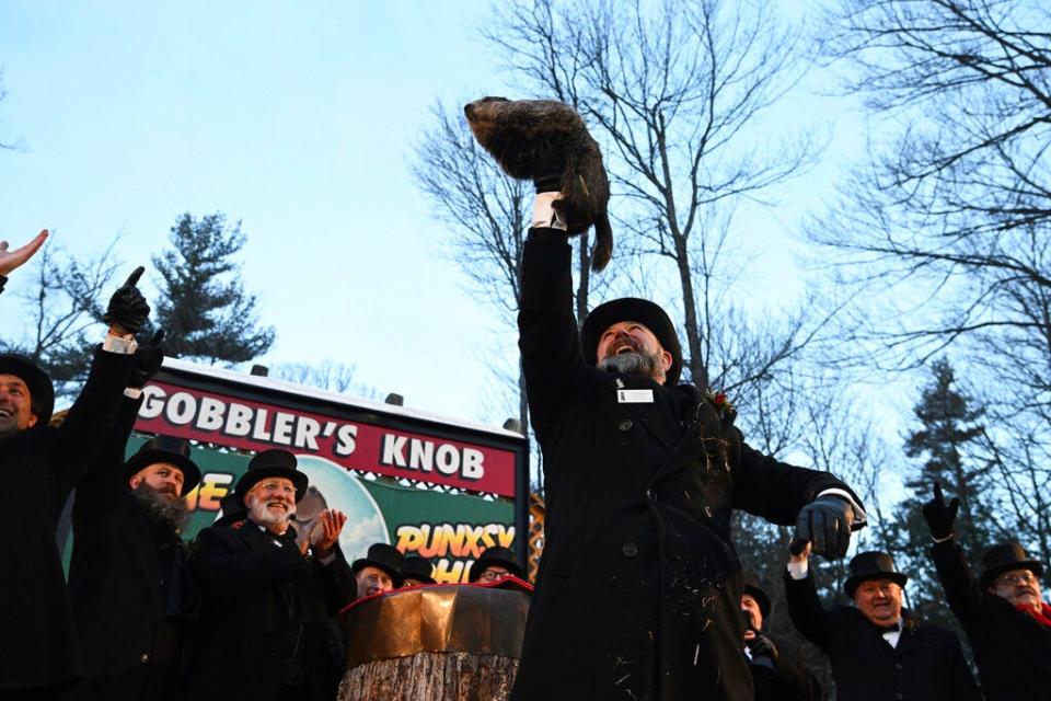 FILE - Groundhog Club handler A.J. Dereume holds Punxsutawney Phil, the weather prognosticating groundhog, during the 136th celebration of Groundhog Day on Gobbler's Knob in Punxsutawney, Pa., Feb. 2, 2022. On Thursday, Feb. 2, 2023, people will once again gather at Gobbler’s Knob as members of Punxsutawney Phil’s “inner circle” summon him from his tree stump at dawn to learn if he has seen his shadow. According to folklore, if he sees his shadow there will be six more weeks of winter. If he does not, spring comes early