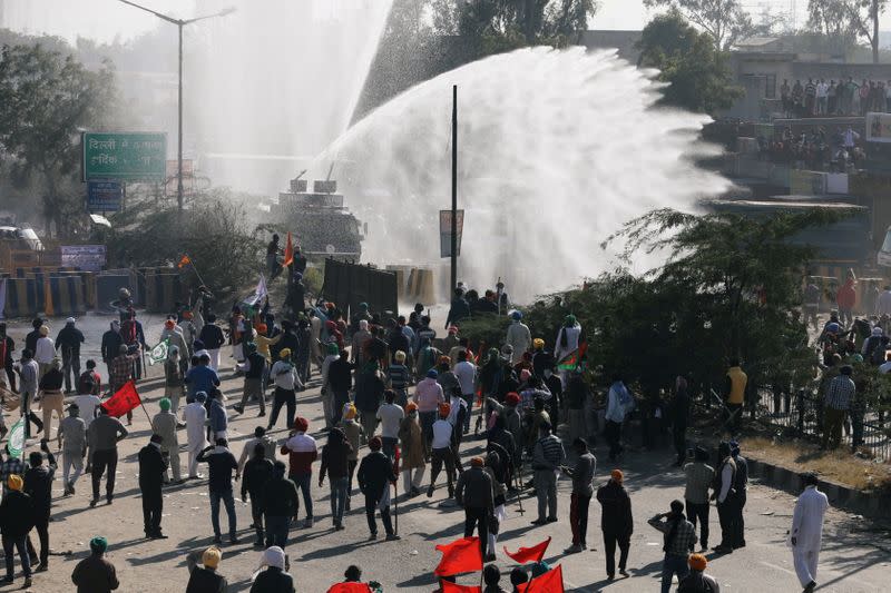 FILE PHOTO: Police officers use water cannon to disperse farmers protesting against the newly passed farm bills at Singhu border near Delhi