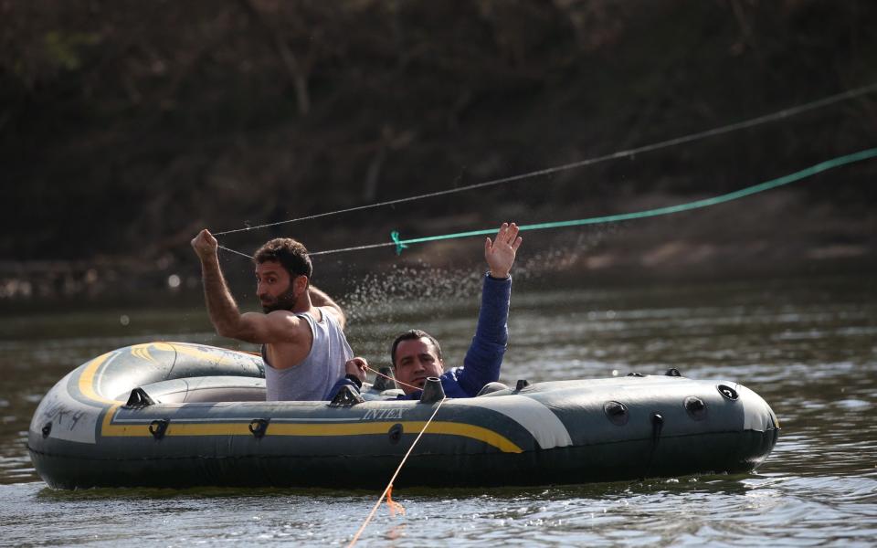 Migrants in a small boat try to cross the Evros River on the Turkish-Greek border, 2020 - Rex/EPA